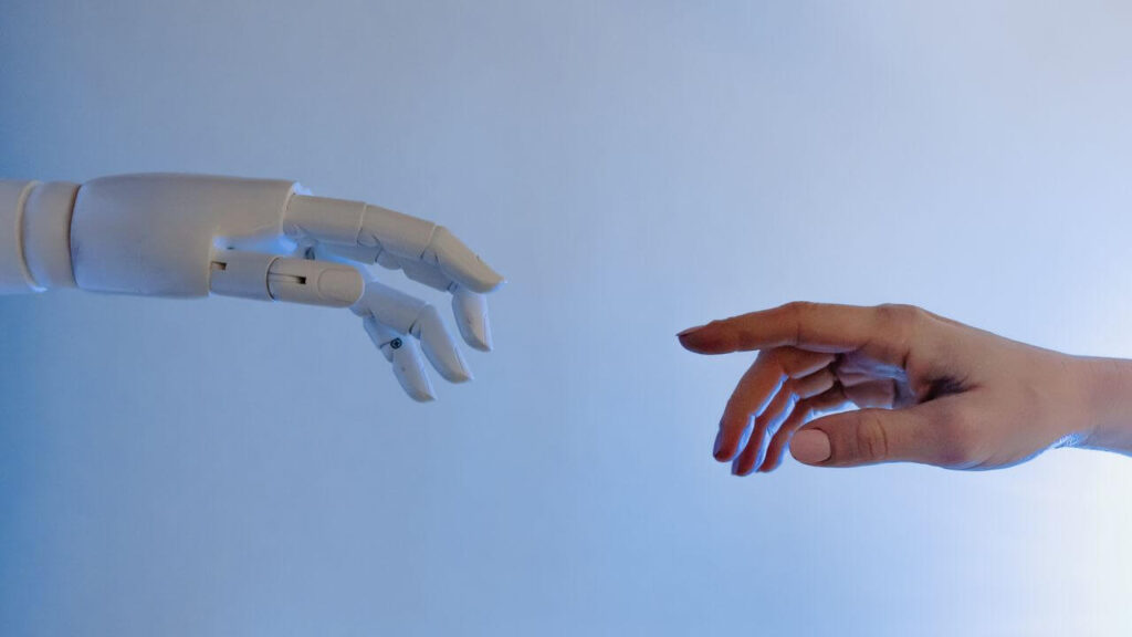 Robotic hand reaching toward an outstretched human hand against a light blue background, symbolizing human oversight and data privacy in external LLM governance.