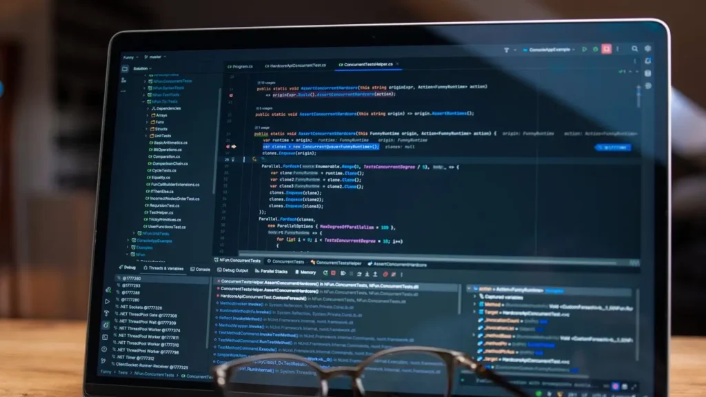 Laptop screen showing software code with glasses on the keyboard, illustrating whether you can build machine learning models without coding